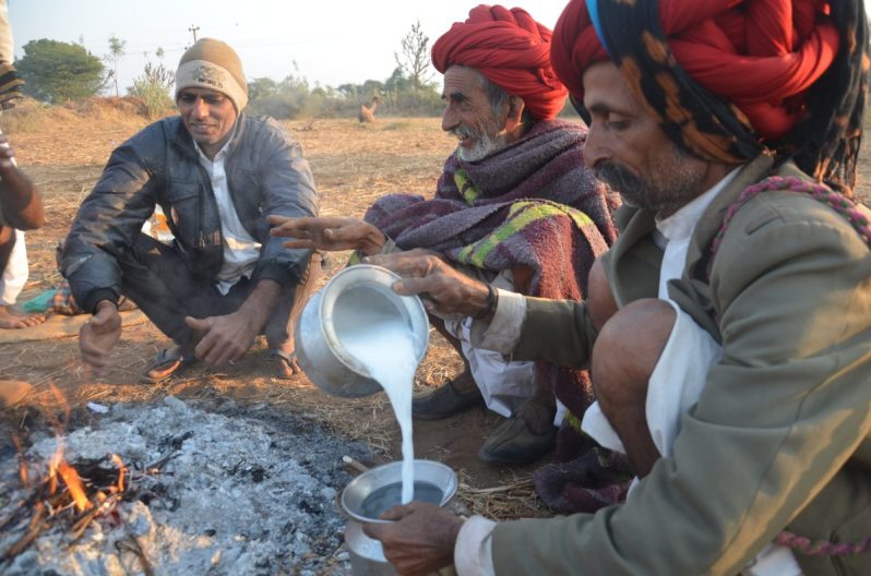 pastoralists pouring milk from a metal jug